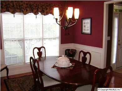 THE FORMAL DINING ROOM WITH HARDWOOD FLOORS, DETAILED CROWN MOLDING, WAINSCOTING, AND FLOOR TO CEILING WINDOWS FOR PLENTY OF SUN LIGHT.