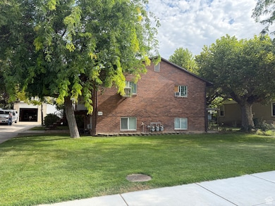 View of side of property with brick siding, a yard, and driveway