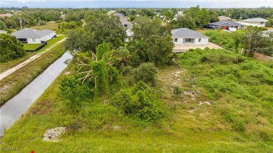 Drone / aerial view of a nearby body of water and a tree filled landscape