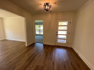 Foyer featuring ornamental molding and dark hardwo
