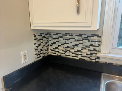 Kitchen with tile backsplash and solid surface counters