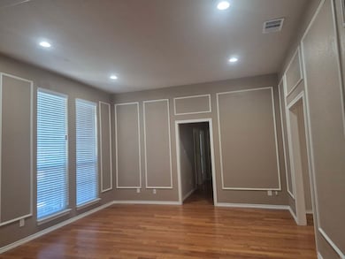 Unfurnished bedroom with light wood finished floors, recessed lighting, and a decorative wall
