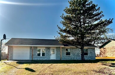 Single story home featuring a garage and a front y
