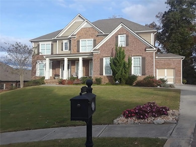 Craftsman-style home with a porch, a front yard, brick siding, a garage, and concrete driveway