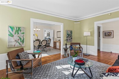 Living room featuring a chandelier, crown molding, wood finished floors, and wainscoting