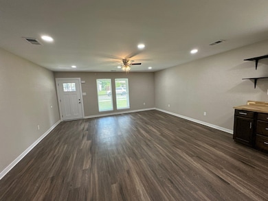Unfurnished living room with ceiling fan, dark wood finished floors, and recessed lighting