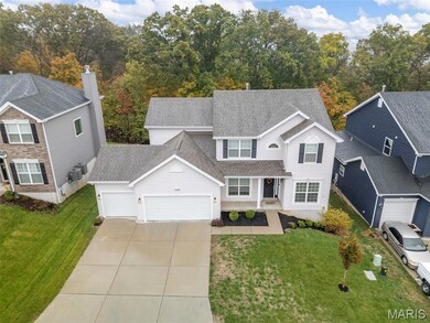 Traditional-style home with a shingled roof, a front yard, an attached garage, and driveway