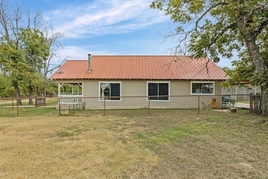 Rear view of house with a metal roof and a fenced