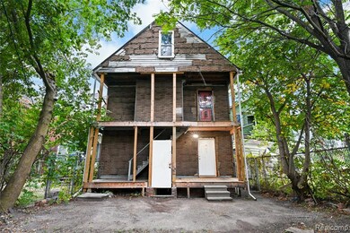 View of front facade with brick siding and a balcony