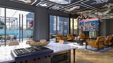 Kitchen featuring wood-type flooring, stainless steel microwave, light stone countertops, and plenty of natural light