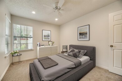 Bedroom with a textured ceiling, ceiling fan, and 