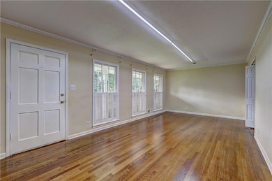 Spare room with wood finished floors and ornamental molding