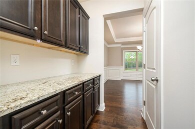 Kitchen featuring a wainscoted wall, dark wood-sty