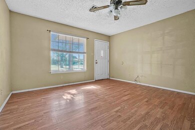 Entryway with a textured ceiling, hardwood / wood-