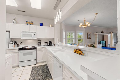 Kitchen with a sink, white appliances, light count