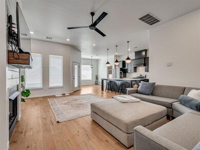 Living room featuring a ceiling fan, light wood-type flooring, a fireplace, recessed lighting, and baseboards