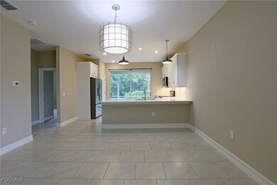 Kitchen with white cabinetry, a peninsula, stainle