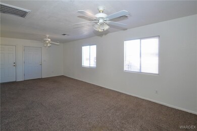 Carpeted spare room featuring ceiling fan