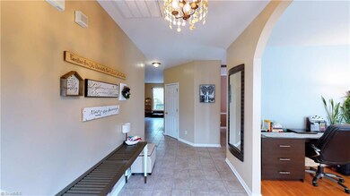 View from the front door.   Gorgeous chandelier, hard surface flooring, and neutral color scheme.