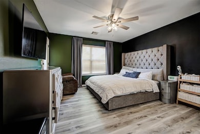 Bedroom with light wood finished floors and a ceiling fan