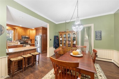 Dining room with ornamental molding, an inviting chandelier, sink, and dark hardwood / wood-style flooring