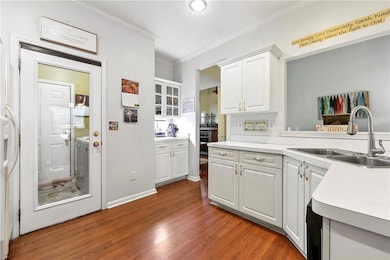 Kitchen featuring light countertops, a sink, dark 