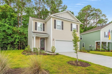View of front of property with an attached garage, board and batten siding, driveway, and a front yard