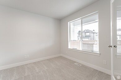 Empty room with carpet floors, baseboards, and visible vents