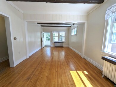 Unfurnished room with crown molding, radiator, and