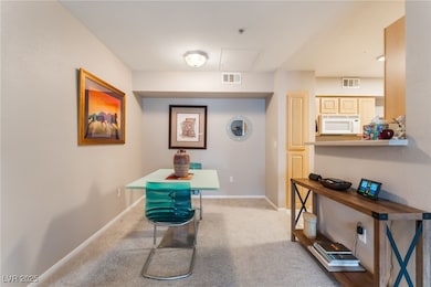 Hall featuring carpet, baseboards, and attic acces