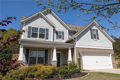 Craftsman-style home featuring covered porch, concrete driveway, brick siding, and a garage