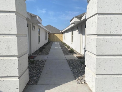View of exterior entry with stucco siding and fence
