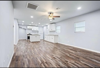 Unfurnished living room with recessed lighting, dark wood-style floors, and a ceiling fan