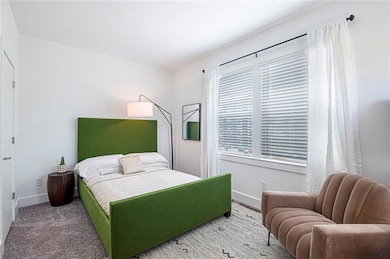 Bedroom featuring light carpet