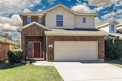 Traditional-style house featuring brick siding, a shingled roof, driveway, and a front lawn