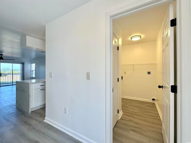 Hallway featuring light wood-style flooring and baseboards