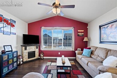 Living room featuring vaulted ceiling, dark wood-t