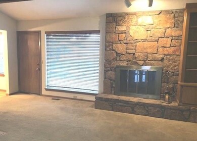 The spacious living room has a great rock fireplac