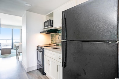 Kitchen featuring black appliances, decorative bac