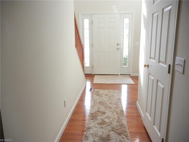 Foyer entranceway with hardwood floors and half ba