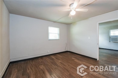 Living room featuring dark wood-style floors, cooling unit, and ceiling fan