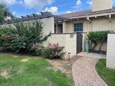 View of side of property with a gate, a chimney, a tiled roof, and stucco siding