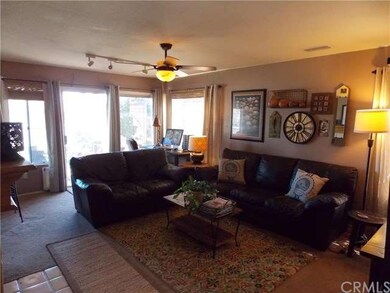 Family room w/fireplace, ceiling fan, and sliders 