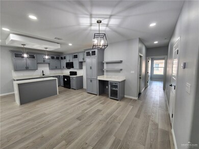 Kitchen featuring black appliances, gray cabinets, sink, and decorative light fixtures