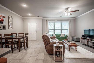 Living room with ornamental molding and ceiling fan