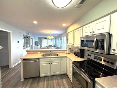 Kitchen with light countertops, a sink, visible ve