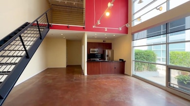 Unfurnished living room featuring a towering ceiling, concrete flooring, and stairs
