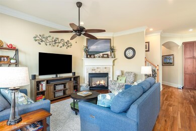 Living room featuring crown molding, ceiling fan, 