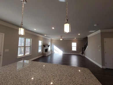 Kitchen with crown molding, open floor plan, a fireplace with raised hearth, recessed lighting, and ceiling fan