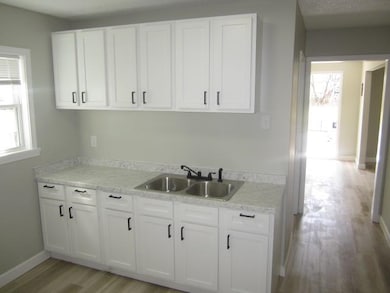 Kitchen featuring baseboards, light wood finished 